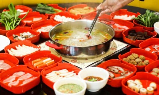 a bowl of soup is being served with chopsticks